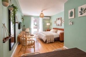 A cozy bedroom with a bed, bedside table, lamp, and a hanging plant.