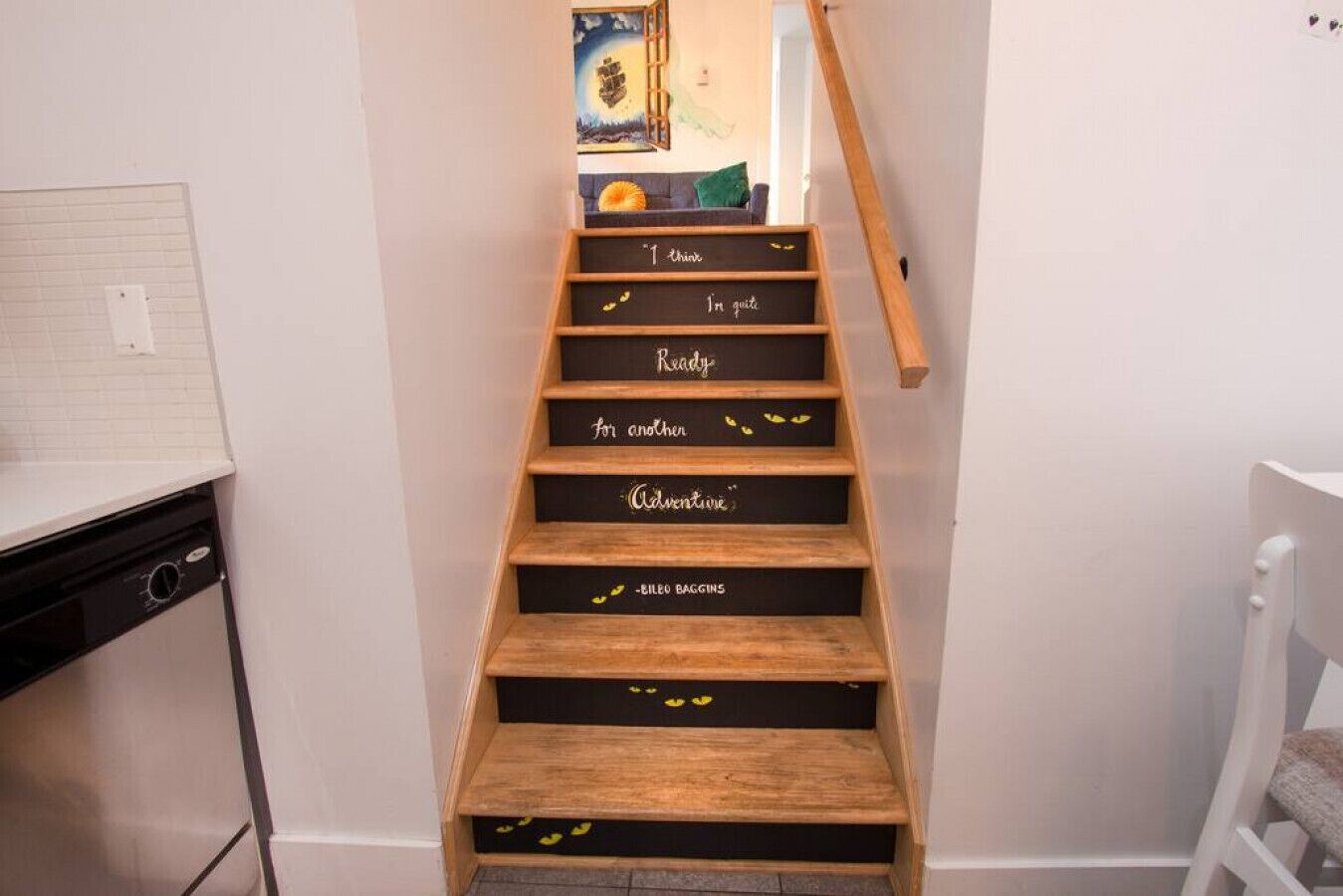 A staircase with wooden steps and black backplates with motivational phrases.