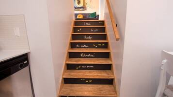 A staircase with wooden steps and black backplates with motivational phrases.