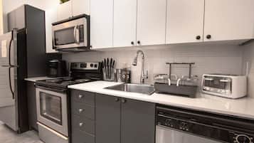 A modern kitchen with a built-in microwave, stove, and dishwasher.