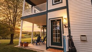 A two-story house with a porch, a door with a number, and a welcome sign.