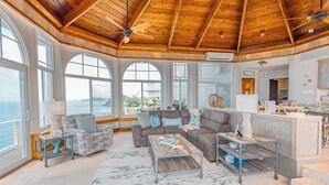 A spacious living area with a wooden ceiling, large windows, and a view of the ocean. - Unrivaled Oceanfront Views In Our Private Caribbean Resort (St Thomas)