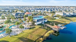 Resort com vários edifícios, piscina e um cais sobre a água.
