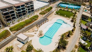 Vista aérea de um hotel com piscina, vários edifícios e áreas ajardinadas.