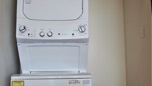 Uma máquina de lavar e secar empilhadas, com painéis de controle e etiquetas.