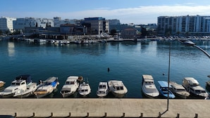 A marina with several boats docked, a clear sky, and buildings in the background. - 3. Double room with sea view (Zadar)