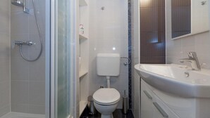 A modern bathroom with a glass shower enclosure, a toilet, and a sink with a mirror above it. - 3. Double room with sea view (Zadar)