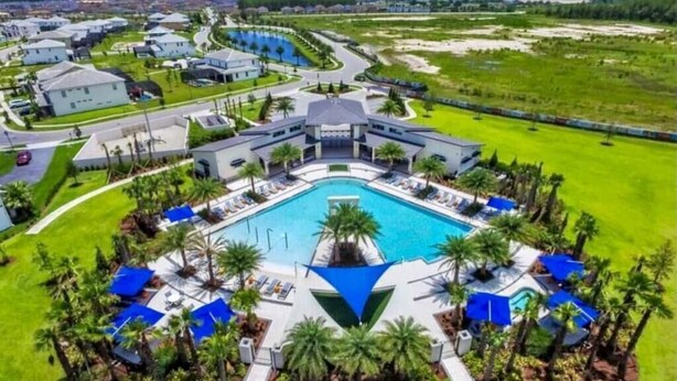 Ein großes Resort mit einem zentralen Schwimmbad, mehreren Villen und gepflegten Rasenflächen.