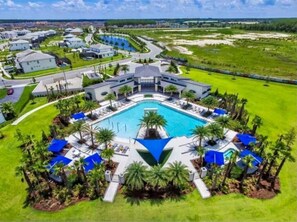 Un gran complejo turístico con una piscina central, varias villas para huéspedes y céspedes bien cuidados.