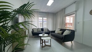 A modern living room with two sofas, a coffee table, and a large potted plant. - Ruim Modern Familie Appartement in Torrevieja Spanje (Torrevieja)