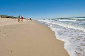 Enjoy a serene beach experience with gentle waves lapping at the shore.