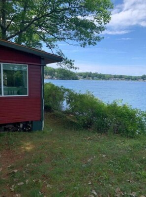 Situated near the water, this cabin offers a serene natural setting surrounded by lush greenery and trees.