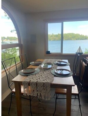 Enjoy meals with a view from this dining area, featuring a large table for four and a beautiful arched window.
