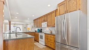 Une cuisine moderne avec des meubles en bois, des appareils en acier inoxydable et un îlot central.