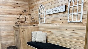 A cozy wooden room with a bed, a decorative wall sign, and a small basket. - Cope's Haven (Fredericksburg)