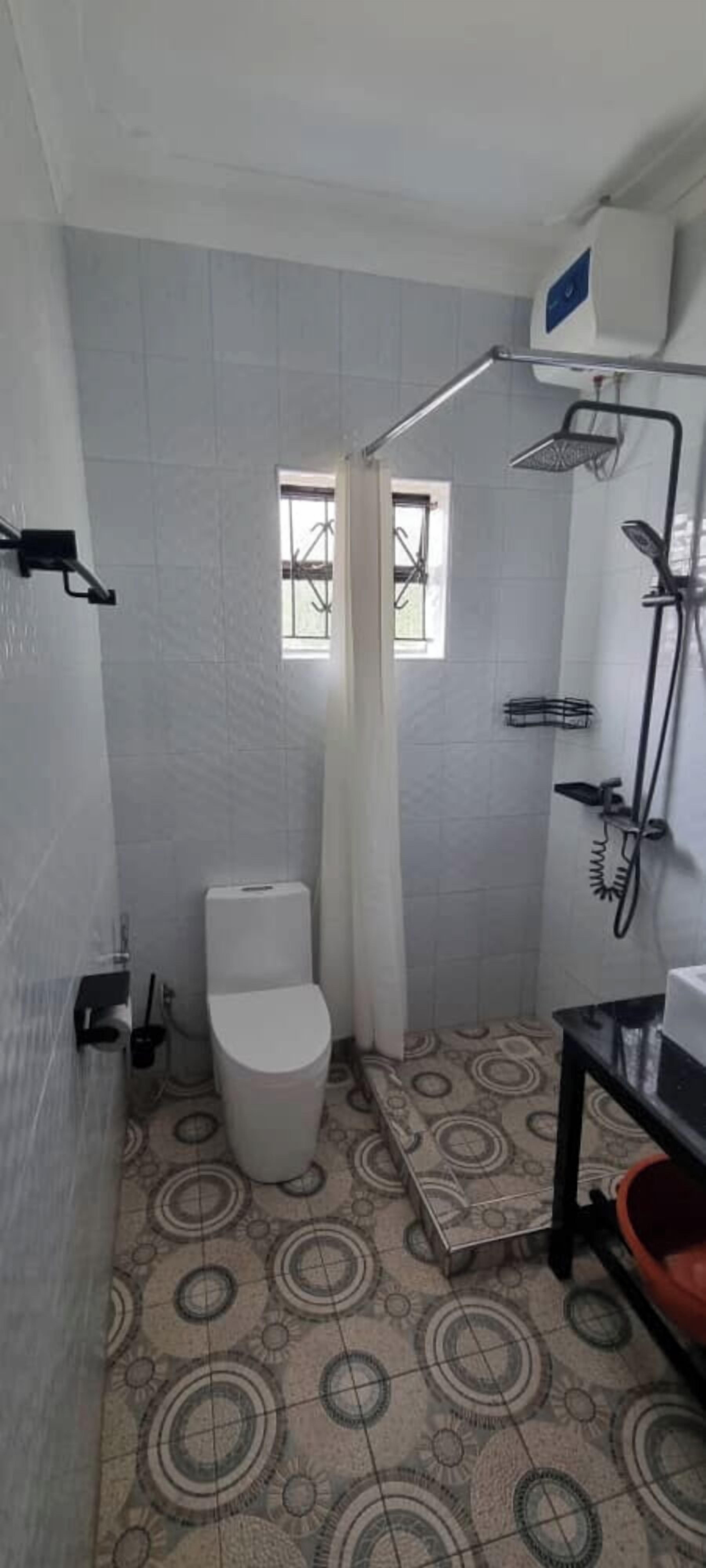 A small bathroom with a toilet, a shower, and a sink.