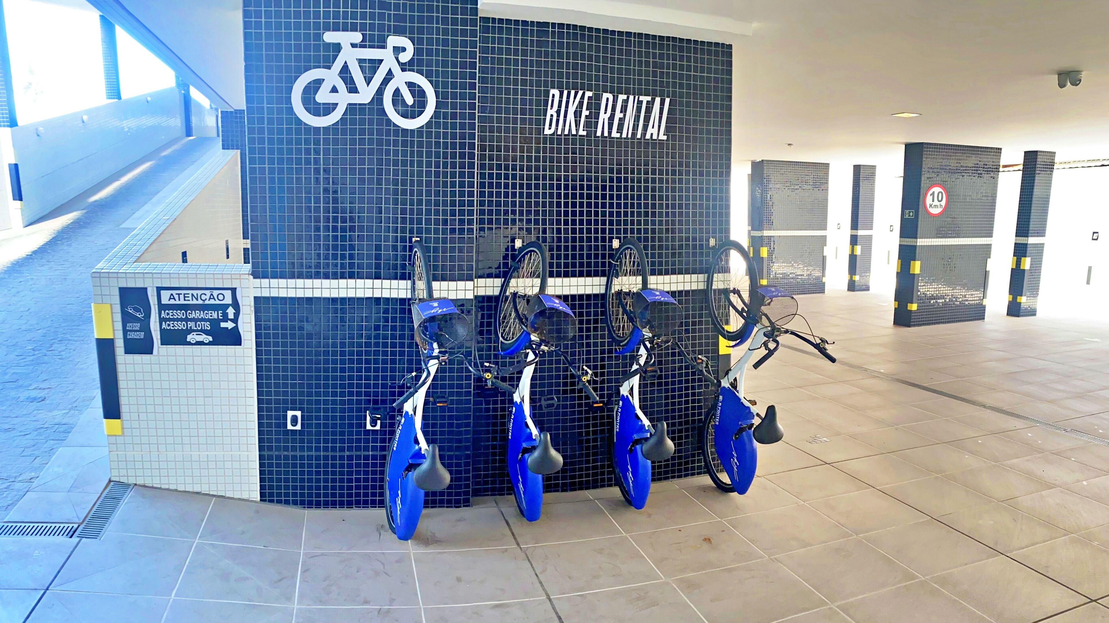 A bike rental station with multiple bicycles and a sign indicating bike rental services.