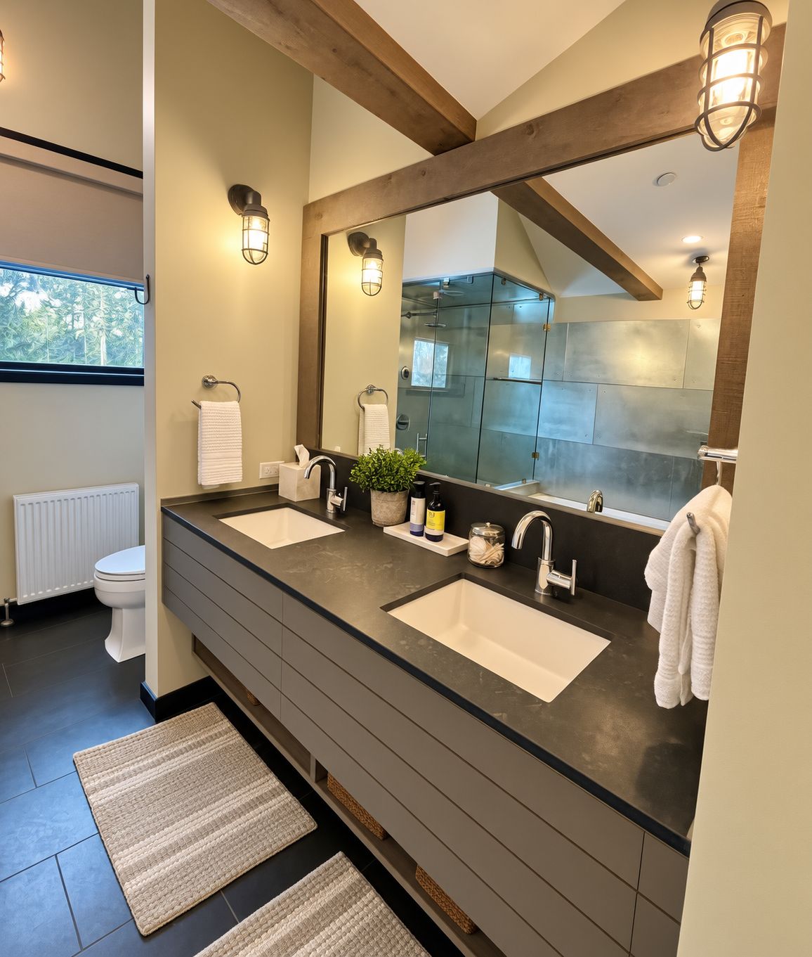 Une salle de bain moderne avec deux lavabos, un grand miroir et une douche à l’italienne.