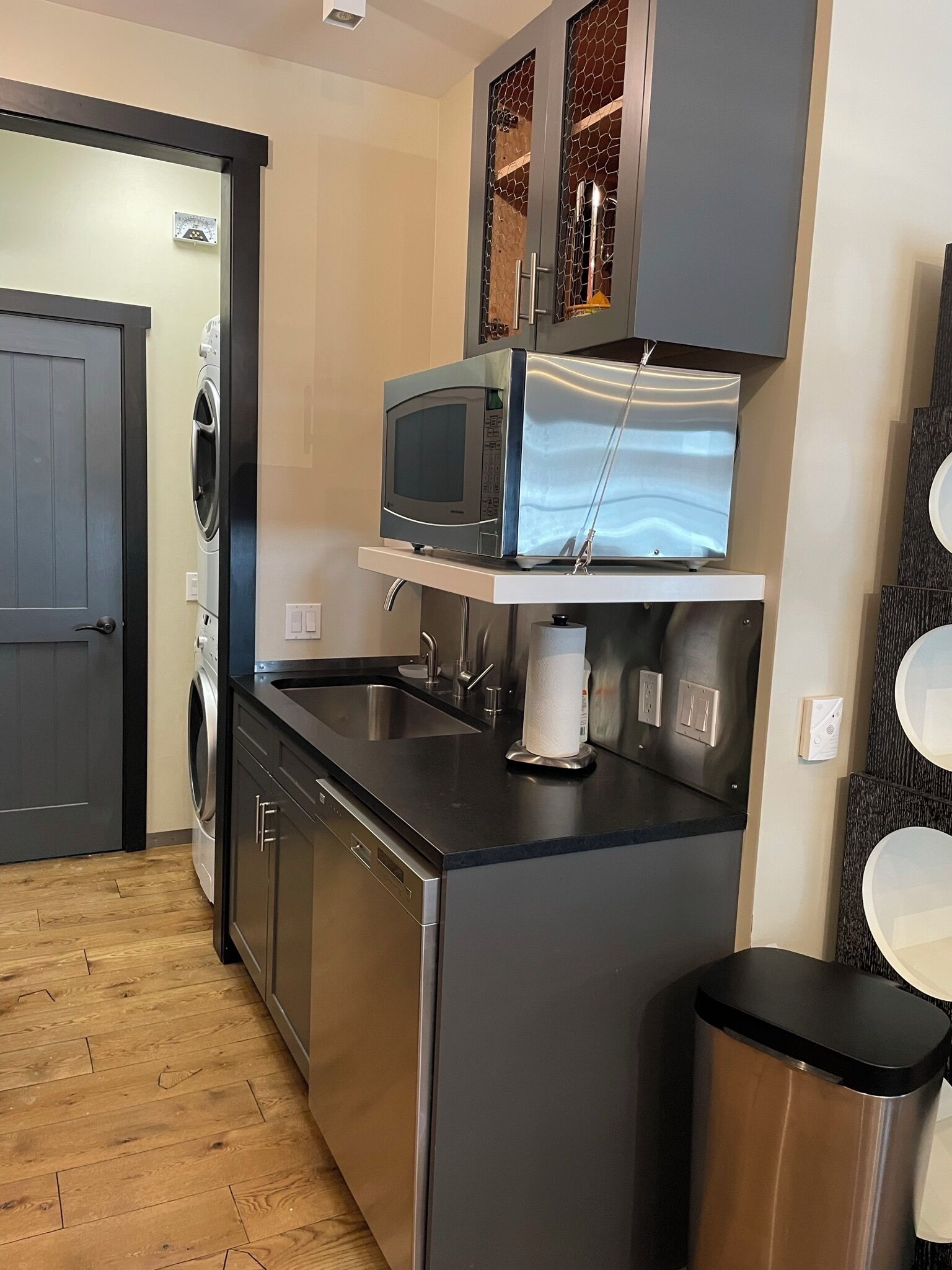 A compact kitchen with a built-in microwave, a sink, and a dishwasher.