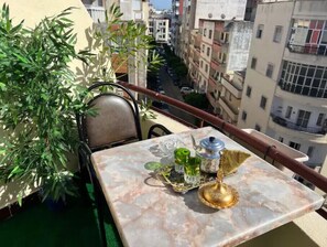 Un balcone con un tavolo, una sedia e una pianta in vaso.