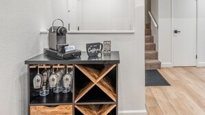 A black counter with a vintage espresso machine, wine glasses, and a sign that reads "Put first Coffee, Wine, Salad." - Bacta Haus 3br/3ba+Loft walk to Village & Canyon (Mammoth Lakes)