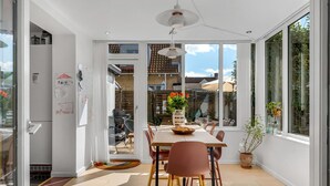 Ein Essbereich mit Tisch, Stühlen und einem Blumenstrauß.
