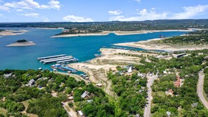 An aerial view of a coastal area with a marina, boats, and a lighthouse.