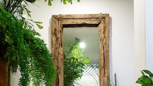 A bathroom with a rustic wooden-framed mirror, a white sink, and a small potted plant. - Villa Mangle Casa Boutique (Cartagena de Indias)