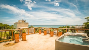 A rooftop terrace with a hot tub, potted plants, and a view of the ocean. - Villa Mangle Casa Boutique (Cartagena de Indias)