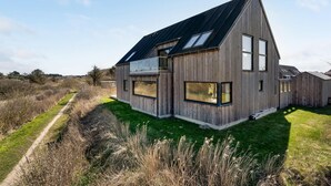 Una casa moderna de madera con ventanas amplias y techo inclinado.