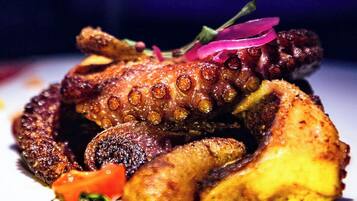 A dish of octopus with vegetables on a plate.