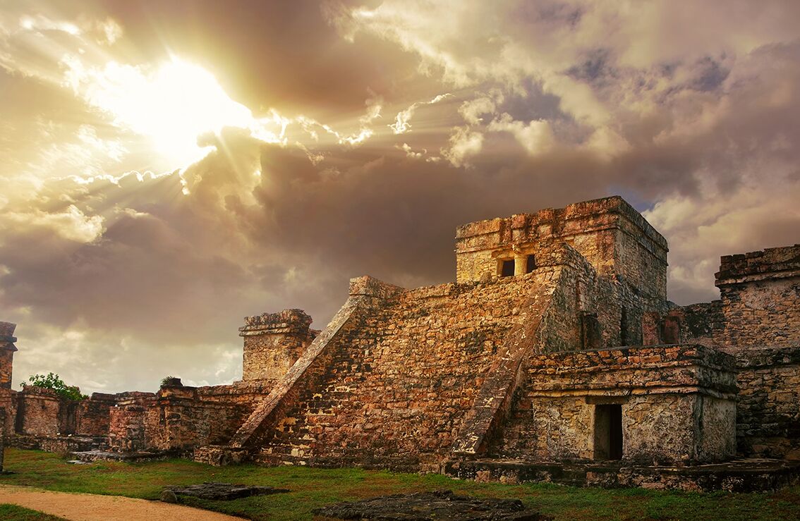 Antiguas ruinas de piedra con una gran pirámide y un edificio más pequeño.