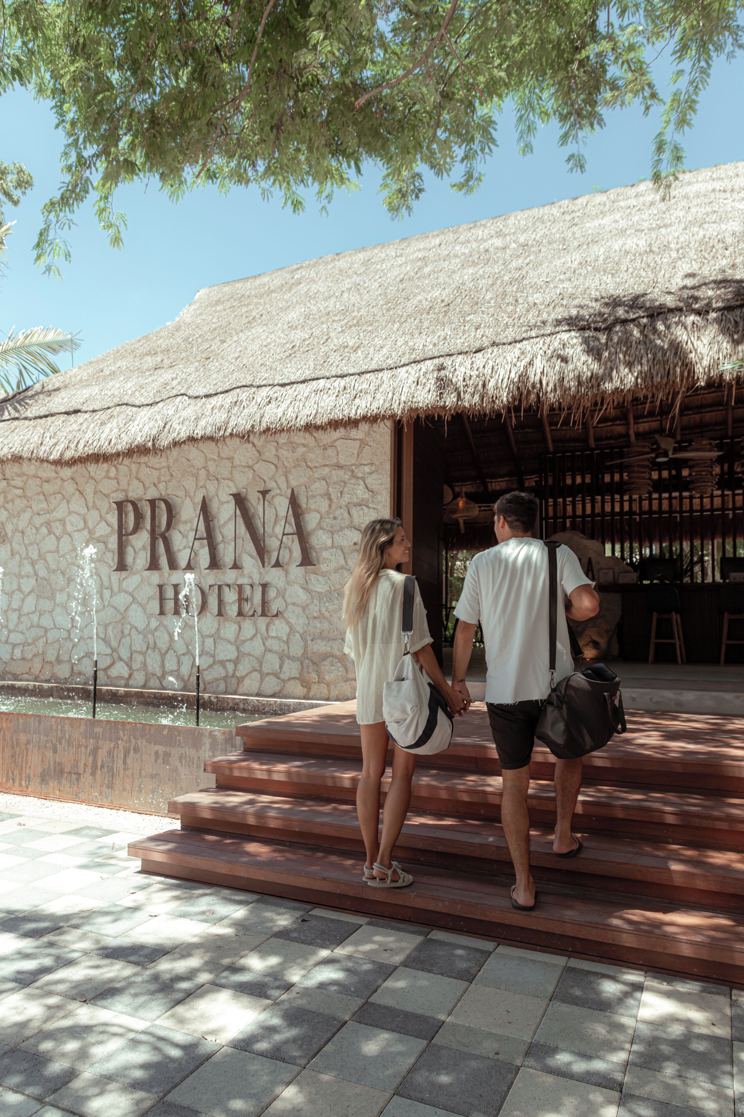 La entrada al HOTEL PRANA, con fachada de piedra y techo de paja.