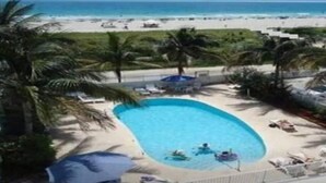 A pool with a view of a beach and ocean.