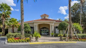 A hotel entrance with a red-tiled roof, a central archway, and a number '2751' above the entrance. - Exquisite Townhome in Emerald Island: A Perfect Blend of Luxury and Comfort (Kissimmee)