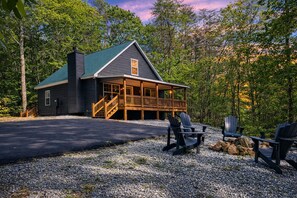Une cabane dotée d’un porche, d’un espace salon extérieur et d’une allée en gravier.