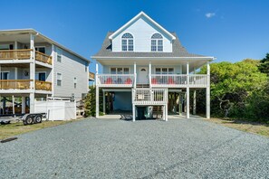 A two-story house with a balcony, a garage, and a gravel driveway. - Topsail Beach Vacation Rental: Idyllic Ocean Views (Topsail Beach)