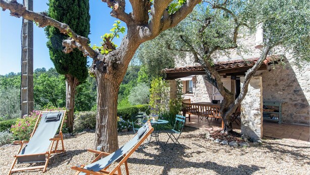 A rustic stone building with a wooden pergola, surrounded by olive trees and a gravel path. - Beautiful home in Fayence (Fayence)