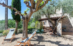 A rustic stone building with a wooden pergola, surrounded by olive trees and a gravel path. - Beautiful home in Fayence (Fayence)