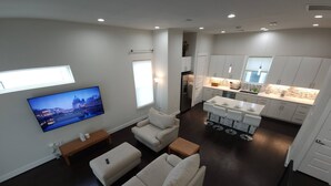 A modern living room with a sofa, a TV, and a kitchen area with a bar. - "modern 3bed Townhome. Near Nrg" (Houston)