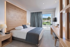 Un moderno cuarto de hotel con cama, mesita de noche, lámpara y vista al exterior.