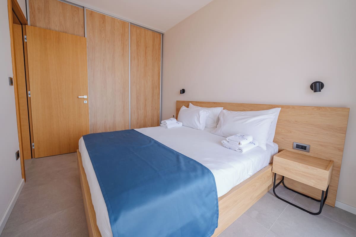 Enjoy a restful stay in this well-appointed room with a comfortable bed, wardrobe, and convenient bedside table.