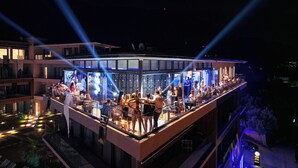 A rooftop bar with a glass enclosure, surrounded by a pool and a cityscape view. - Royal Blue Resort & Residence (Kotor)