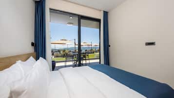 Une chambre d’hôtel avec un grand lit, une vue sur l’espace extérieur et une porte-fenêtre coulissante.