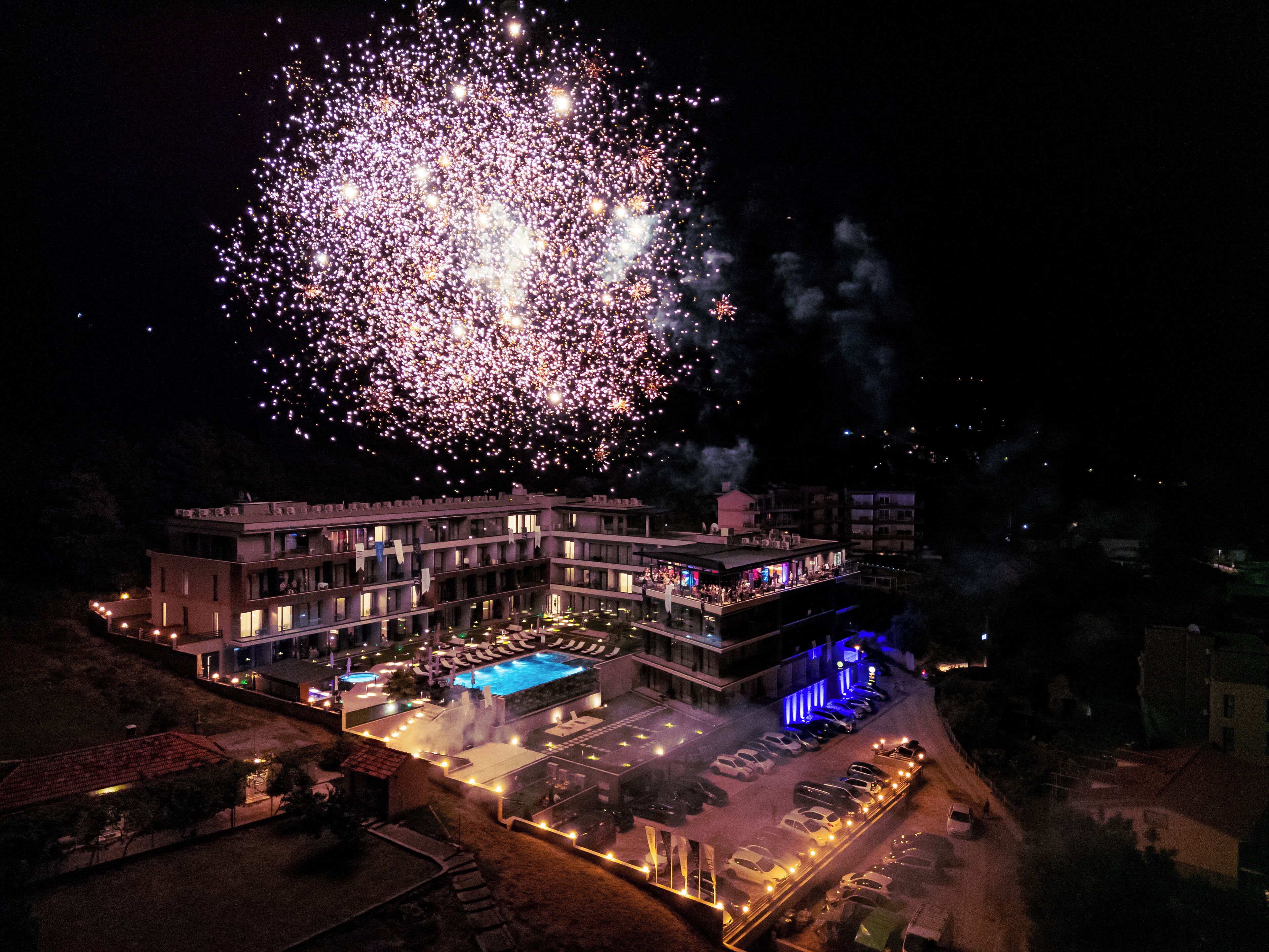 Un hotel con piscina, iluminación exterior y aparcamiento.