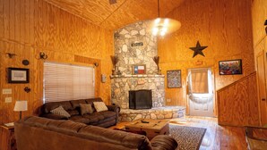 A wooden interior with a stone fireplace, leather sofas, and a star decoration on the wall. - Spacious home with a great view! (Concan)