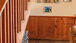 A wooden staircase leading to a landing with a wall-mounted sign reading "FRIO" and two framed pictures. - Spacious Vacation Home with Great Outdoor Amenities (Concan)