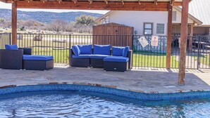 A covered outdoor seating area with a pool, wooden pergola, and a view of the mountains. - Spacious Vacation Home with Great Outdoor Amenities (Concan)