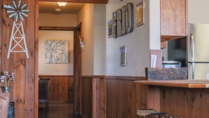 A wooden interior with a windmill decoration, a painting, and a refrigerator. - Spacious Vacation Home with Great Outdoor Amenities (Concan)