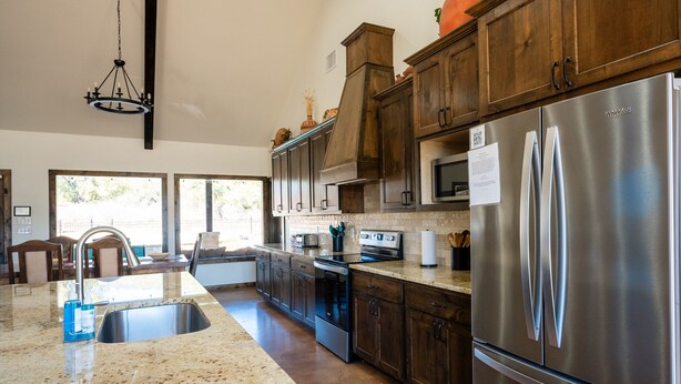 A modern kitchen with granite countertops, stainless steel appliances, and wooden cabinets.
